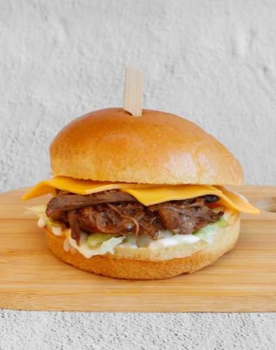 The Burgerzzz in Coatbridge burger with pulled beef, melted cheese, lettuce, and sauce.